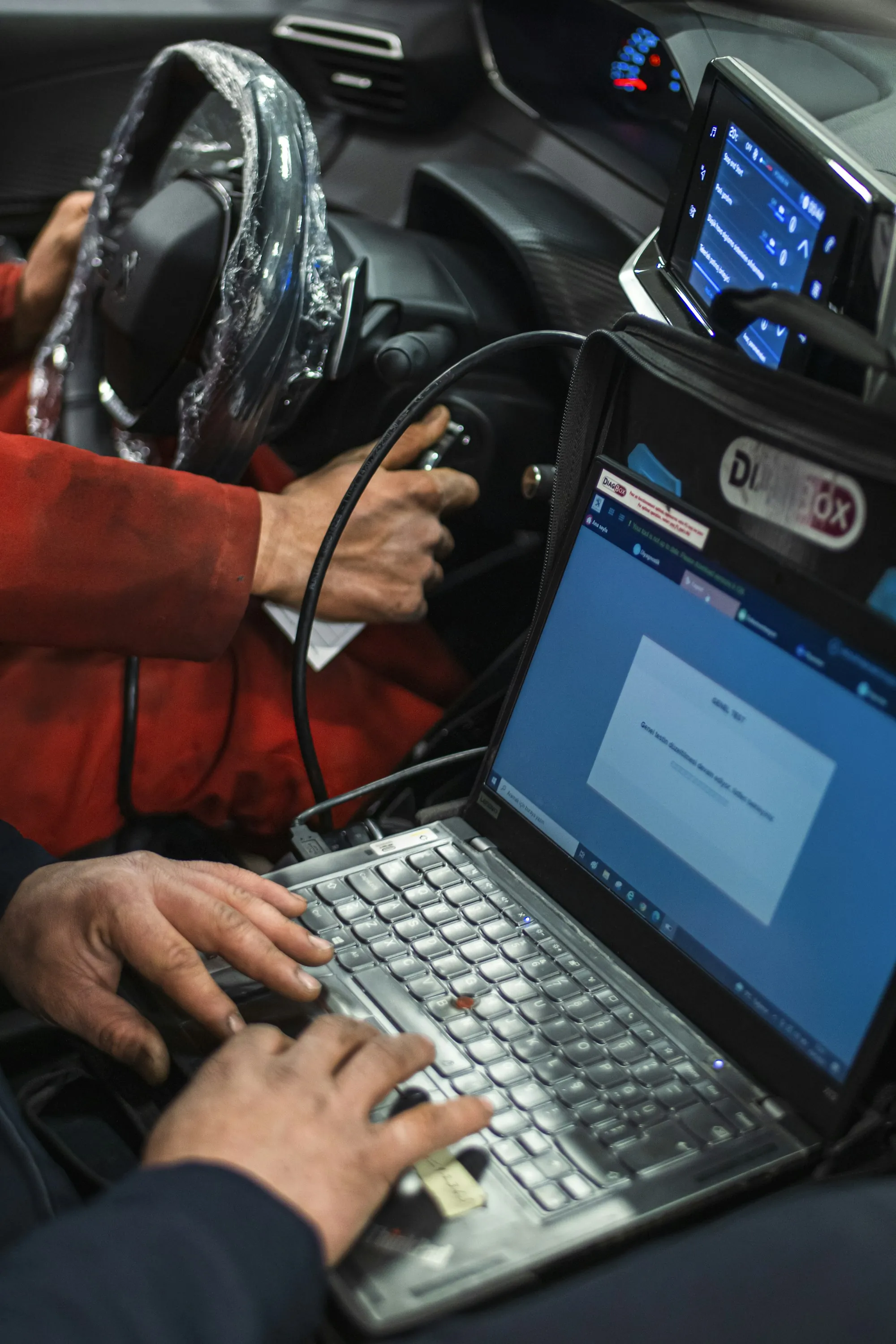 Laptop connected to a vehicle showing diagnostic data